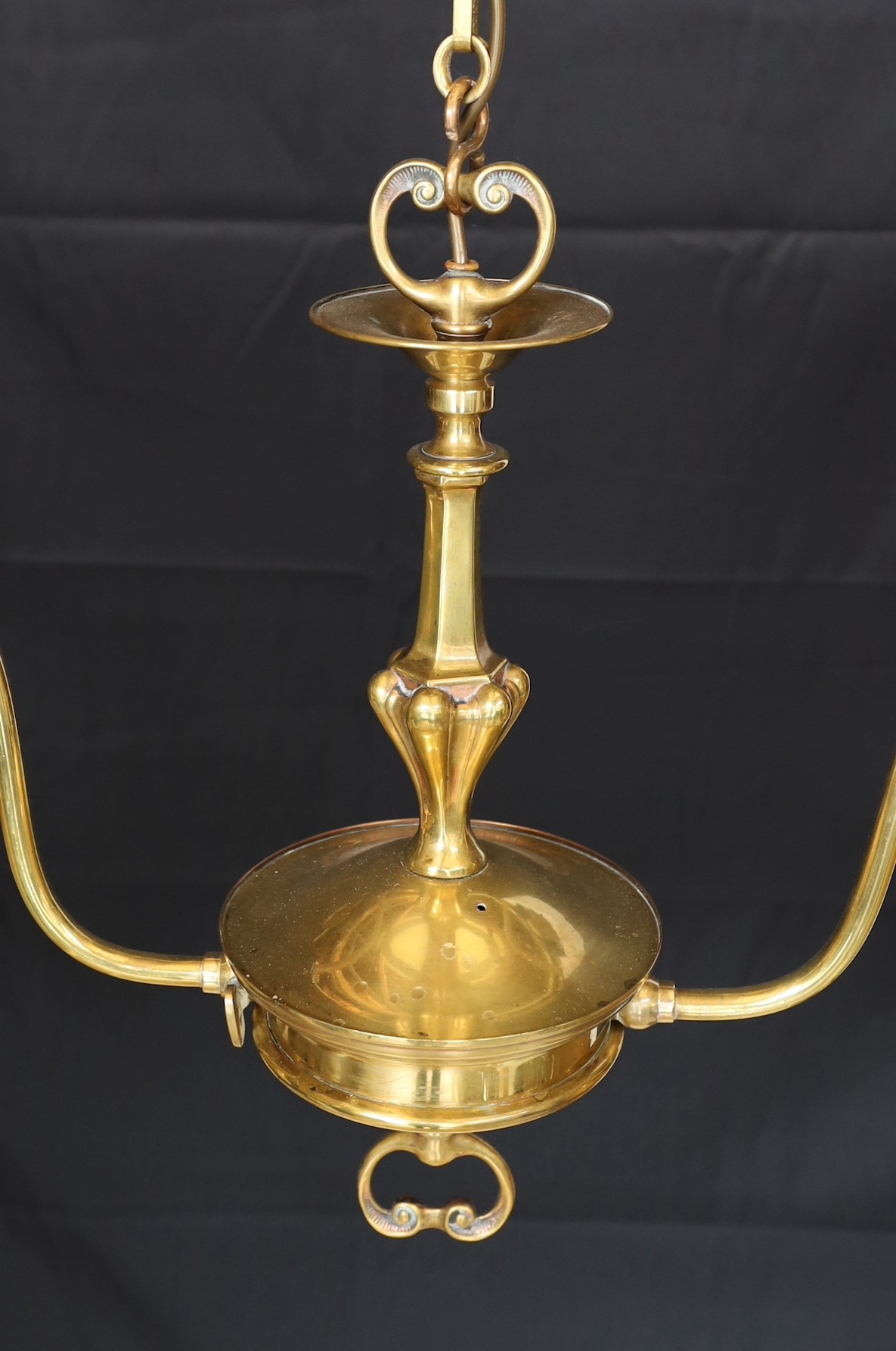 An early 20th century English brass twin branch light fitting with amber tinted tall glass shades height to top of fitting 50cm, width 77cm